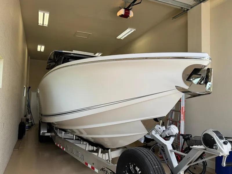Slide: The Image of 2024 Nor-Tech 390 Sport Center Console boat in garage on trailer. - 14