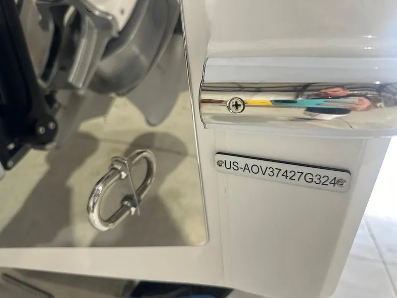 Slide: The Image of 2024 Nor-Tech 390 Sport Center Console boat detail with identification plate and chrome fittings. - 24