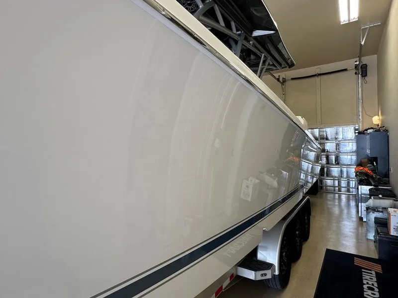 Slide: The Image of 2024 Nor-Tech 390 Sport Center Console boat in a garage, side view. - 30