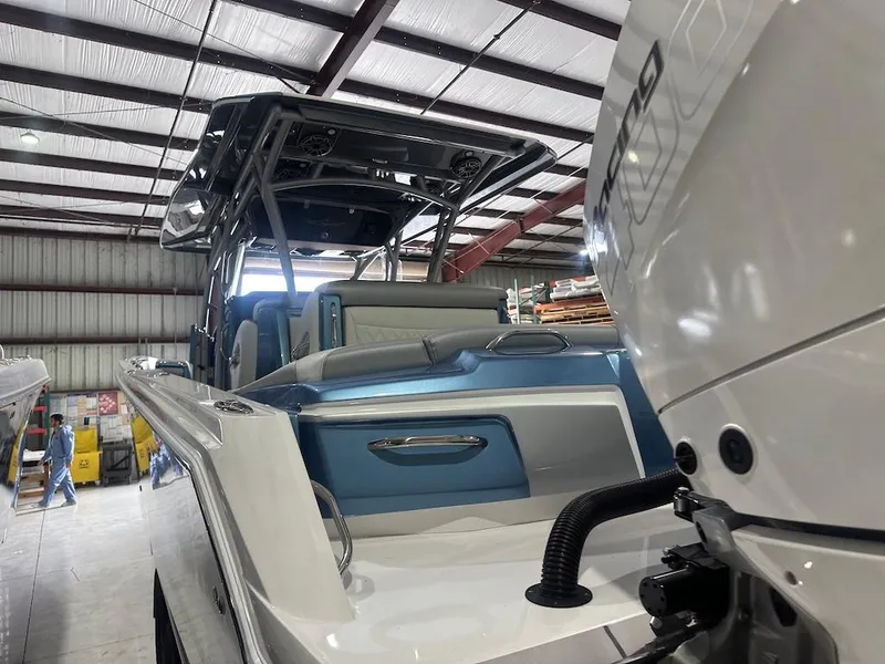 Slide: The Image of 2024 Nor-Tech 390 Sport Center Console boat in a warehouse, showcasing sleek design and powerful engine. - 7