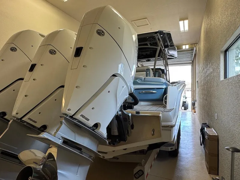 Slide: The Image of 2024 Nor-Tech 390 Sport Center Console with triple outboard engines in a garage. - 8
