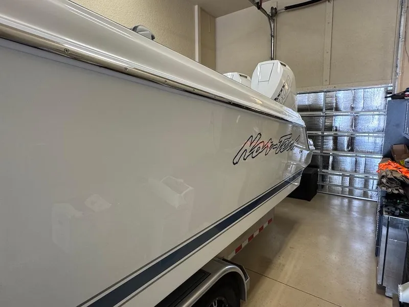 Slide: The Image of 2024 Nor-Tech 390 Sport Center Console boat in garage, side view. - 9