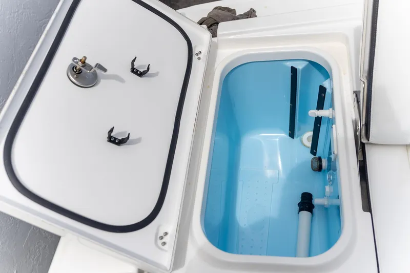 Slide: The Image of Open storage compartment in 2025 Crevalle 24 HCO boat, featuring a blue interior. - 33