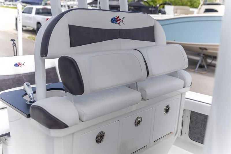 Slide: The Image of 2025 Crevalle 24 HCO boat seating with storage, featuring white and gray upholstery. - 5
