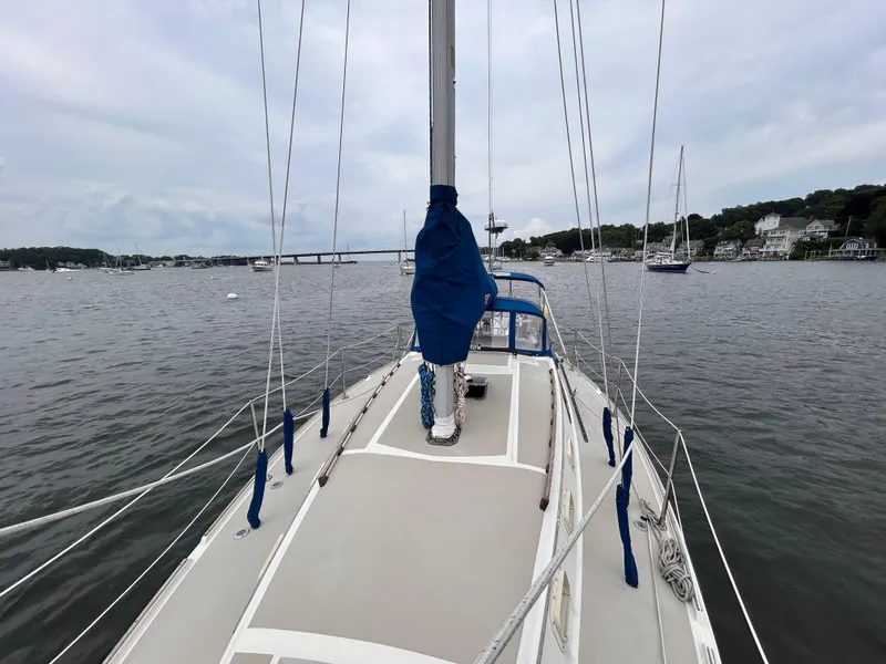 Slide: The Image of 1985 O'Day 35 sailboat on calm water, overcast sky, coastal homes in background. - 10