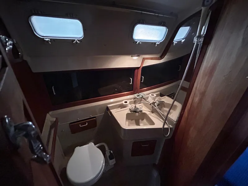 Slide: The Image of Interior of 1985 O'Day 35 sailboat bathroom with sink, toilet, and porthole windows. - 15