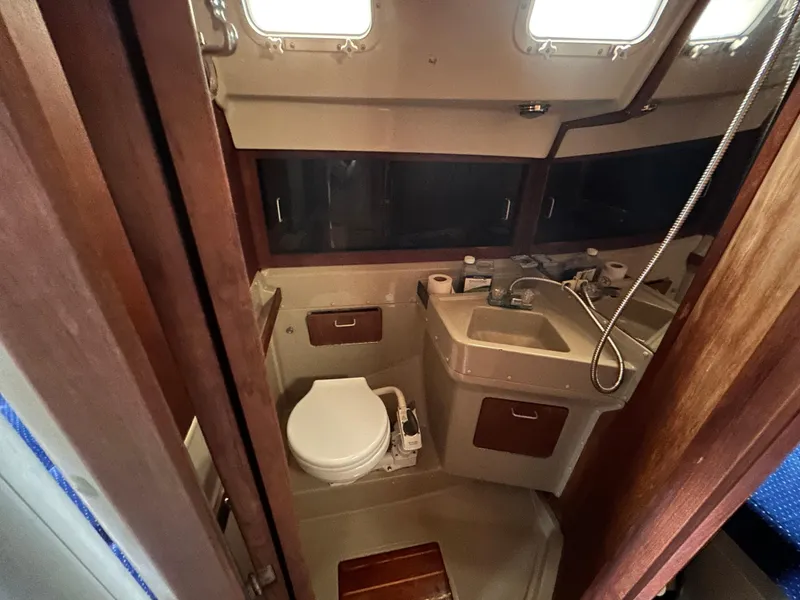 Slide: The Image of 1985 O'Day 35 sailboat bathroom with toilet, sink, and storage cabinets. - 16