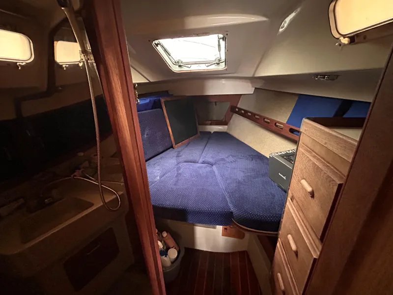 Slide: The Image of Interior cabin of a 1985 O'Day 35 sailboat with blue cushions and wooden cabinetry. - 18