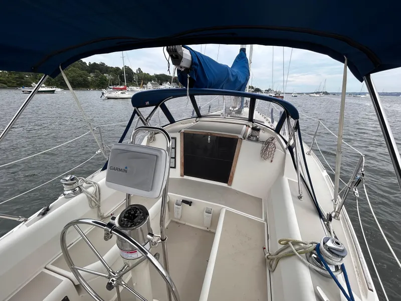 Slide: The Image of 1985 O'Day 35 sailboat cockpit with Garmin navigation, moored in a scenic harbor. - 3
