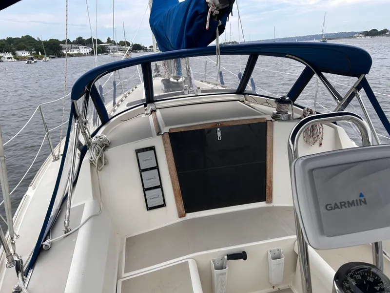 Slide: The Image of 1985 O'Day 35 sailboat cockpit with Garmin navigation, docked on a calm river. - 4