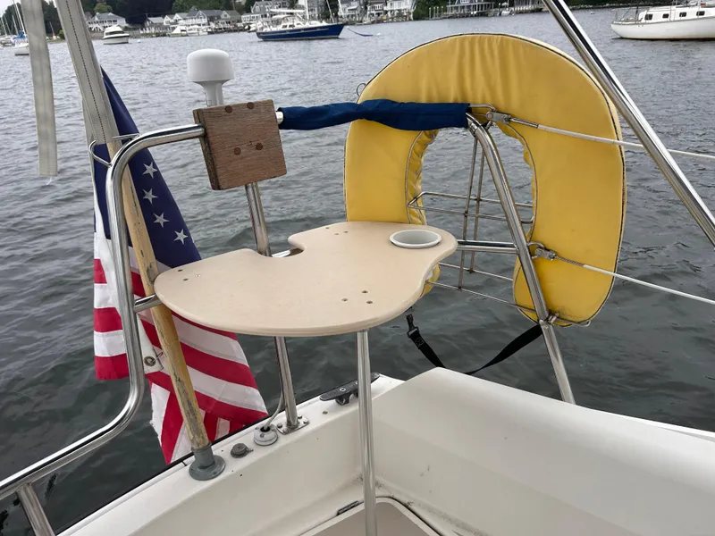 Slide: The Image of 1985 O'Day 35 sailboat stern with American flag and yellow life ring on calm water. - 5