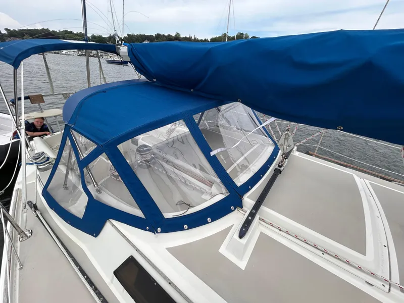 Slide: The Image of 1985 O'Day 35 sailboat with blue canvas cover, docked on a calm lake. - 6