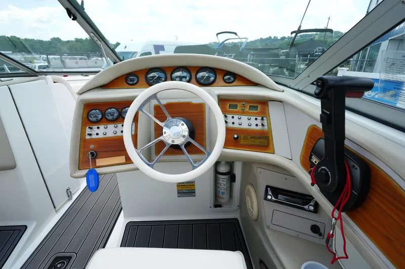 Slide: The Image of 1997 Cobalt 232 boat dashboard with steering wheel and control panel. - 12