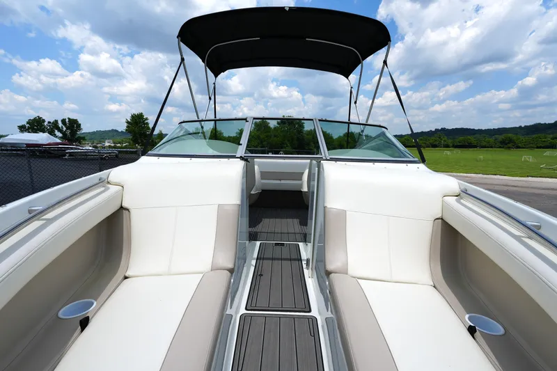 Slide: The Image of 1997 Cobalt 232 boat interior with white seating, open deck, and canopy under a blue sky. - 9