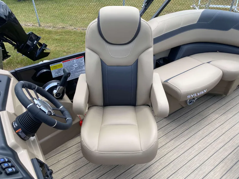 Slide: The Image of 2025 Sylvan L1 LZ Tritoon boat interior with steering wheel and comfortable seating. - 7