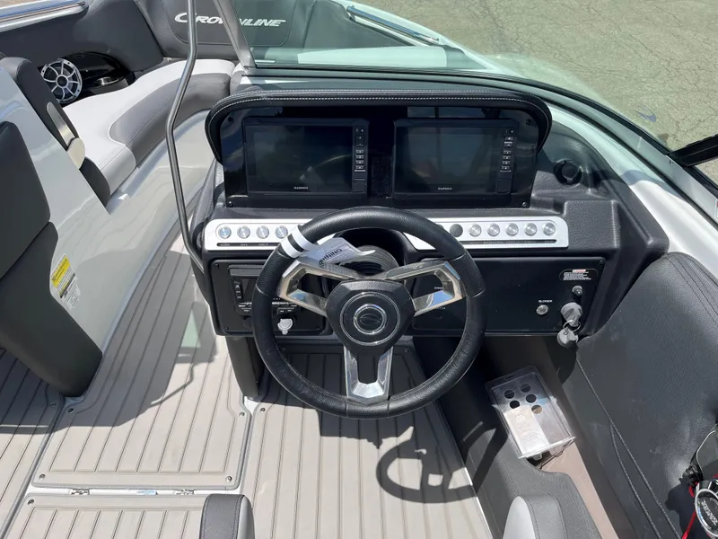 Slide: The Image of 2025 Crownline 220 SS boat dashboard with steering wheel and dual displays. - 11