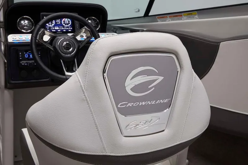 Slide: The Image of 2025 Crownline 220 SS boat interior with steering wheel and branded seat. - 9