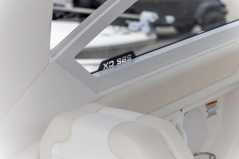 Slide: The Image of Interior view of 2026 Edgewater 262 CX boat, featuring sleek white design and window detail. - 17