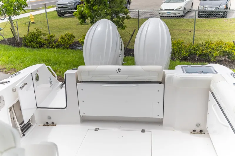 Slide: The Image of 2026 Edgewater 262 CX boat interior with dual outboard motors, white seating, and storage compartments. - 19
