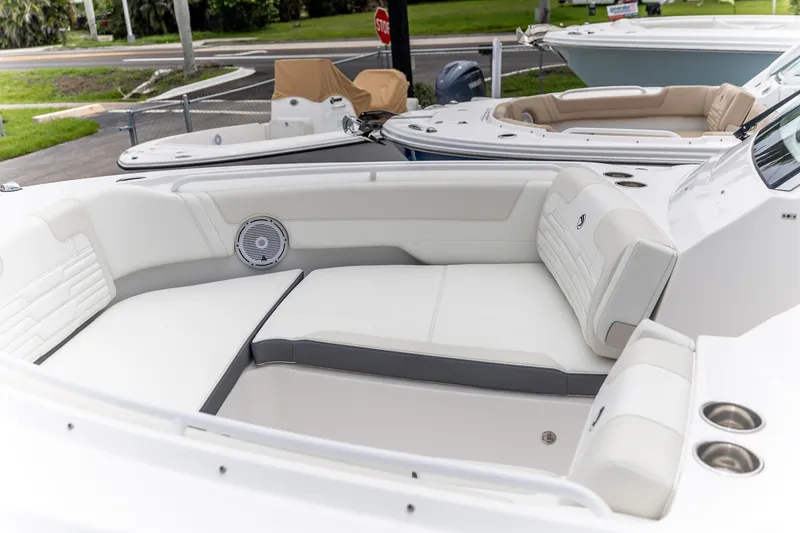 Slide: The Image of 2026 Edgewater 262 CX boat interior with white seating and cup holders. - 28