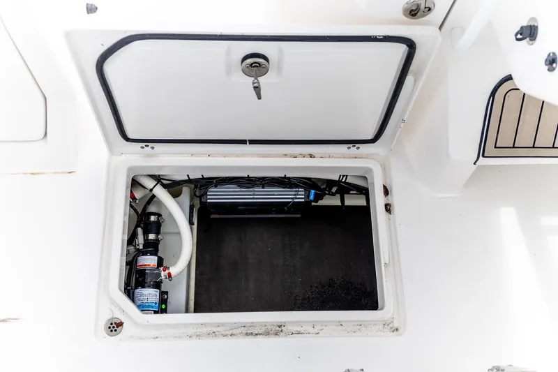 Slide: The Image of Open storage compartment on 2026 Edgewater 262 CX boat, showing internal equipment. - 35