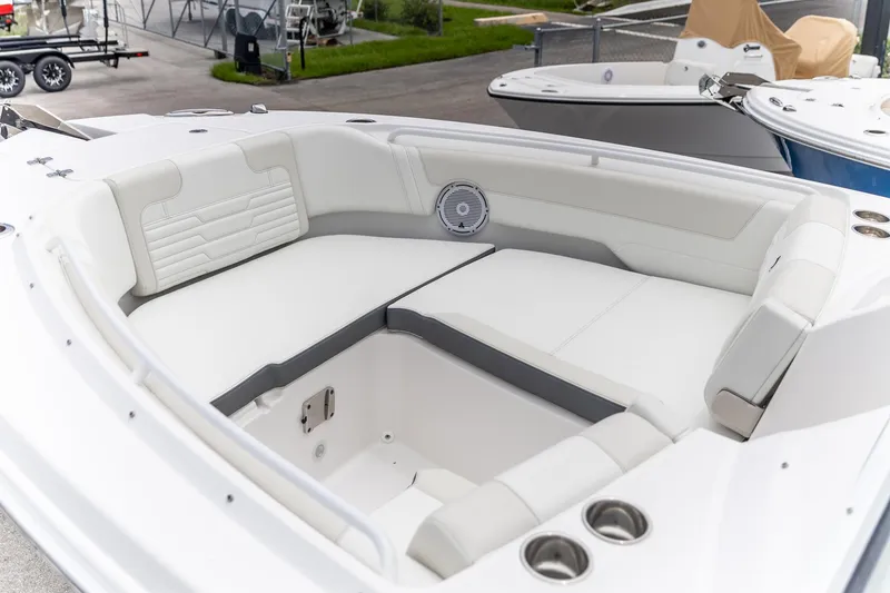 Slide: The Image of 2026 Edgewater 262 CX boat interior with white cushioned seating and cup holders. - 7