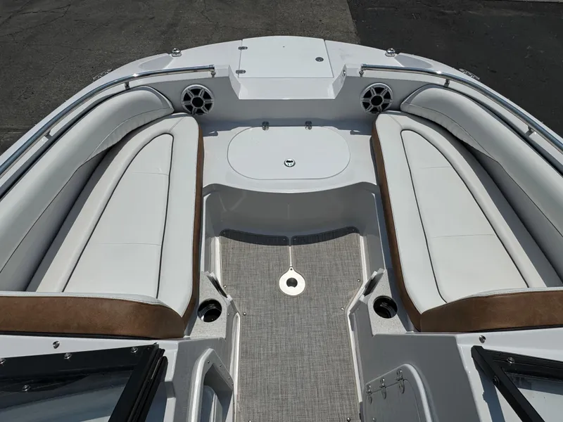 Slide: The Image of 2025 Stingray 201 DC boat interior with white and brown seating, speakers, and deck. - 13