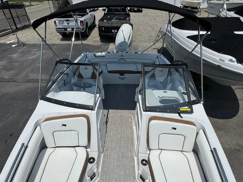 Slide: The Image of 2025 Stingray 201 DC boat with spacious seating and sleek design, parked outdoors. - 15