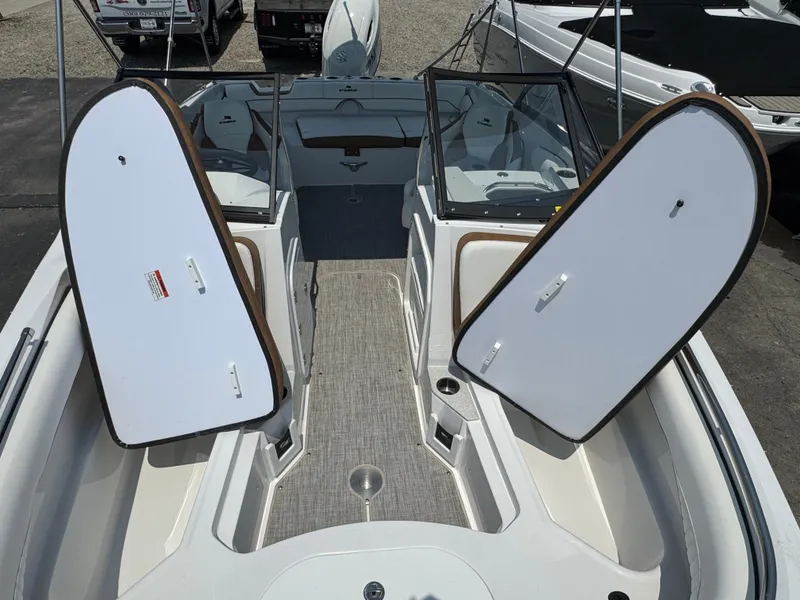 Slide: The Image of 2025 Stingray 201 DC boat interior with open storage compartments and seating area. - 16