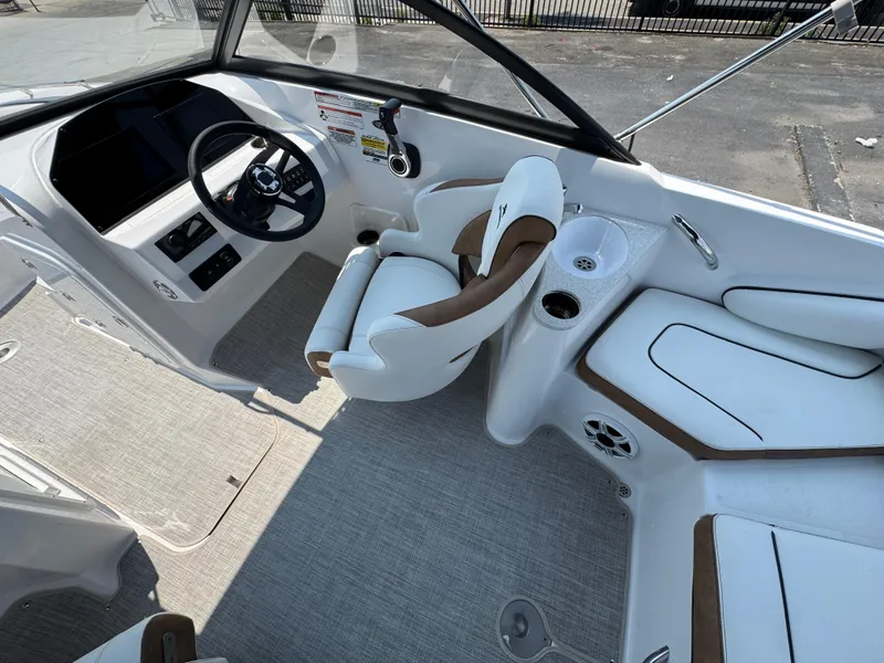 Slide: The Image of Interior of 2025 Stingray 201 DC boat with steering wheel and seating area. - 20