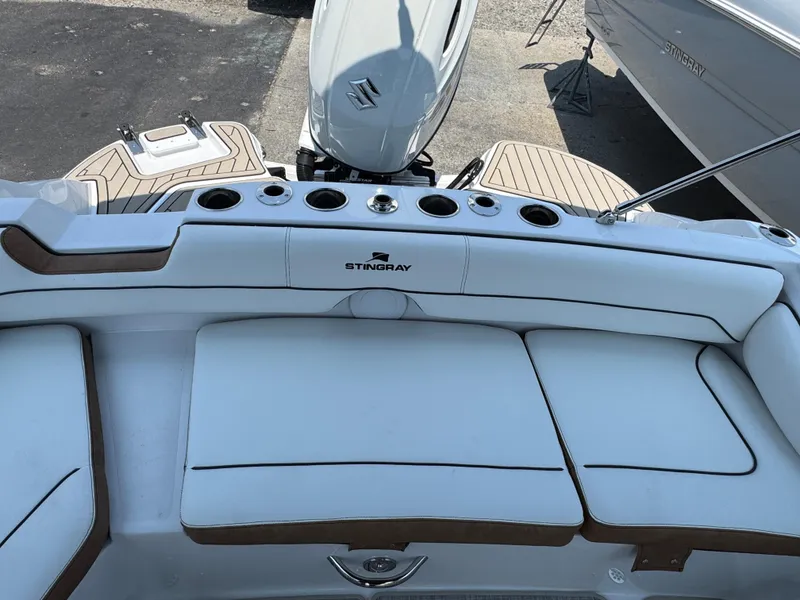 Slide: The Image of 2025 Stingray 201 DC boat interior with white seating and Suzuki outboard motor. - 3