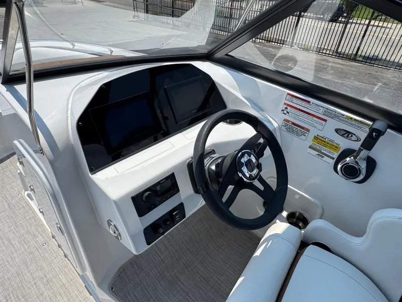 Slide: The Image of 2025 Stingray 201 DC boat dashboard with steering wheel and control panel. - 5