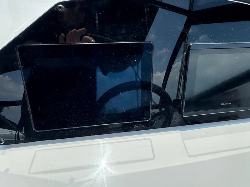 Slide: The Image of 2025 Stingray 201 DC dashboard with Garmin display, reflecting steering wheel and sky. - 6