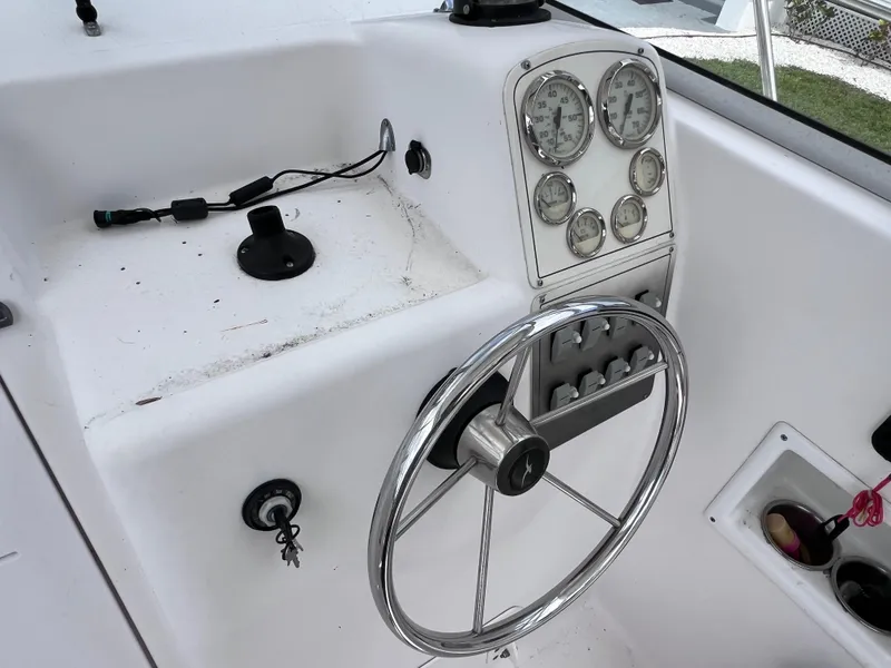 Slide: The Image of 2000 Pro-Line 20 WALK AROUND boat dashboard with steering wheel and gauges. - 15