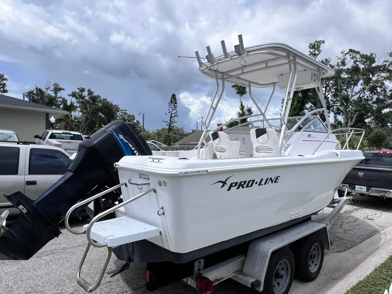 Slide: The Image of 2000 Pro-Line 20 Walk Around boat on trailer, parked outdoors under cloudy sky. - 6
