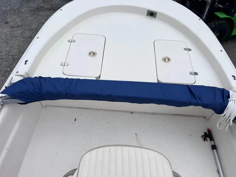 Slide: The Image of 2017 Carolina Skiff 18 JVX CC boat interior with storage compartments and blue cover. - 12