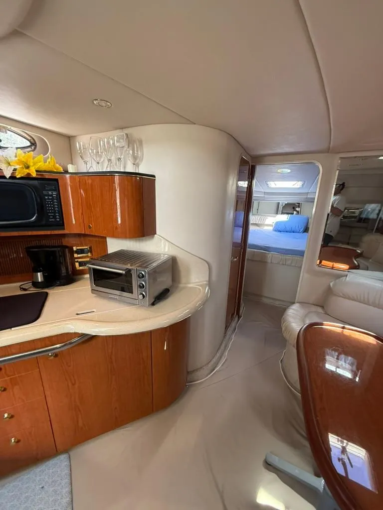 Slide: The Image of Interior of 2000 Sea Ray 380 Sundancer yacht with kitchenette and cozy seating area. - 13