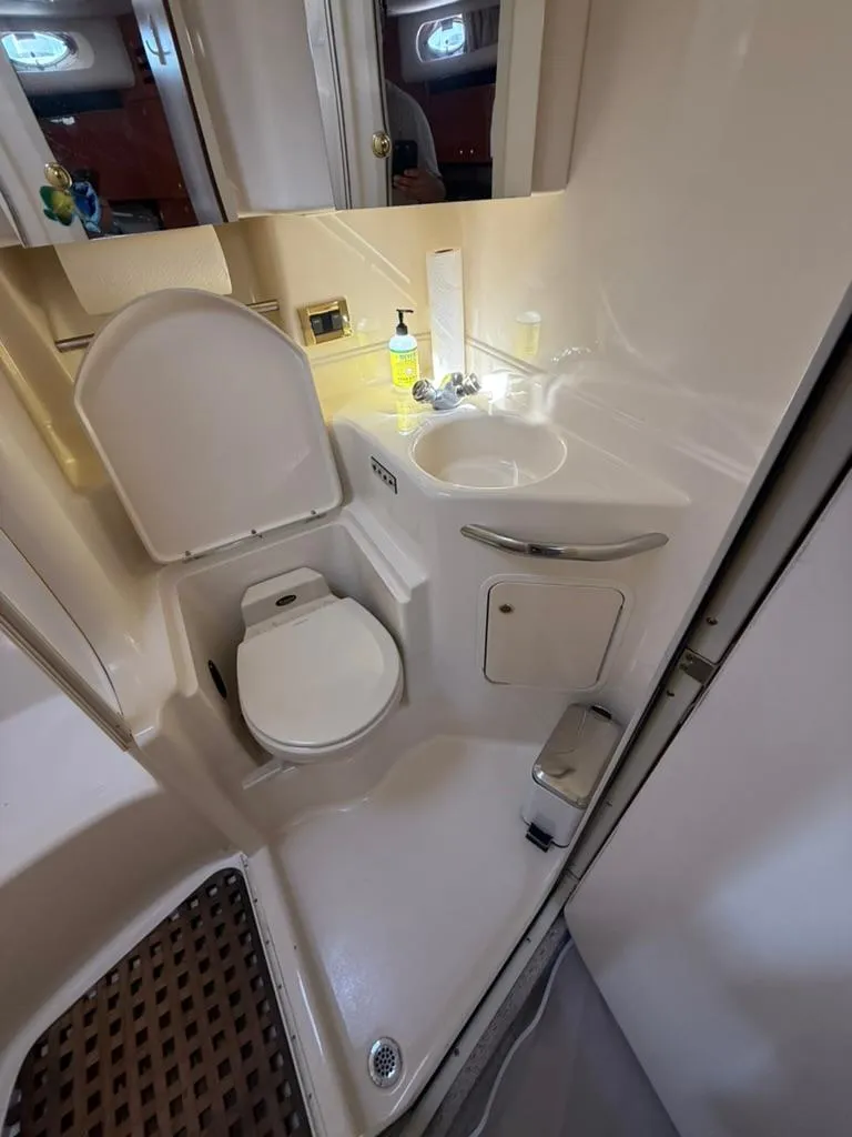 Slide: The Image of Compact bathroom in 2000 Sea Ray 380 Sundancer yacht, featuring toilet and sink. - 15