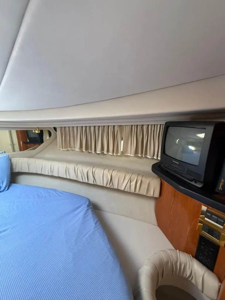 Slide: The Image of Interior of 2000 Sea Ray 380 Sundancer with bed, curtains, and TV. - 9
