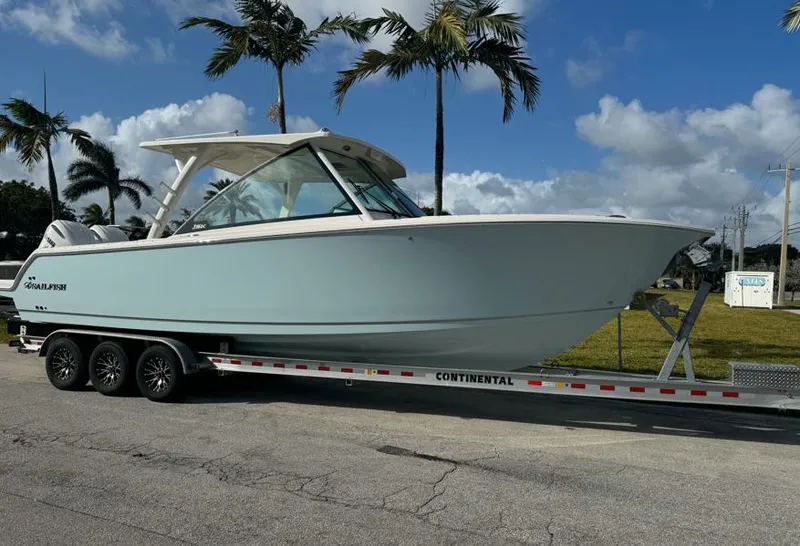 The Image of 2025 Sailfish 316 DC boat docked near palm trees under a clear sky. - 0