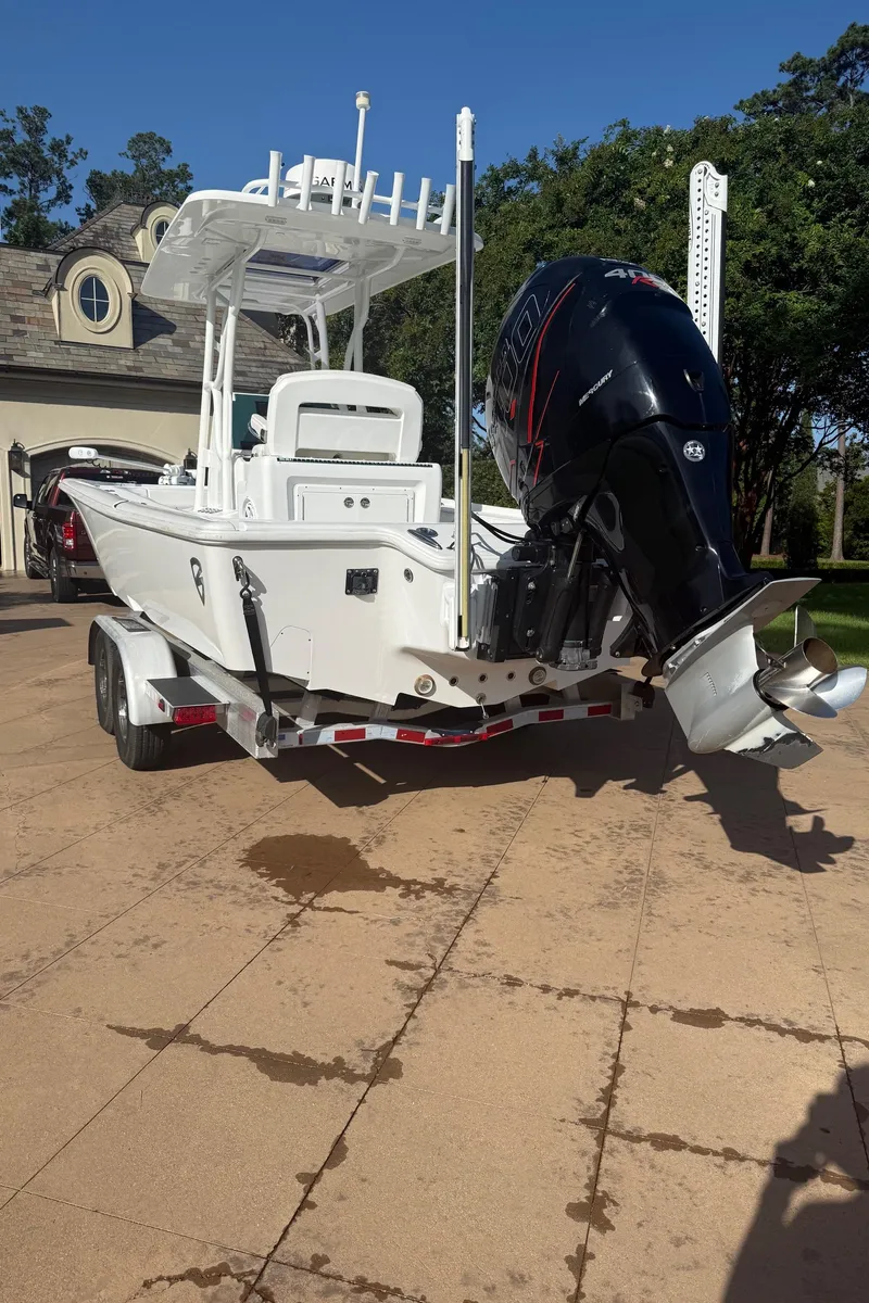 Slide: The Image of 2016 Barker Boatworks Calibouge on trailer, featuring powerful outboard motor, parked on driveway. - 13