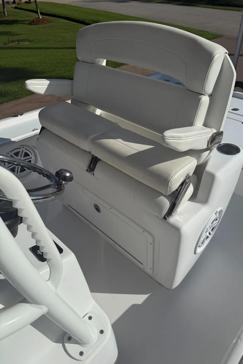 Slide: The Image of 2016 Barker Boatworks Calibouge helm seat with white upholstery and steering wheel. - 8
