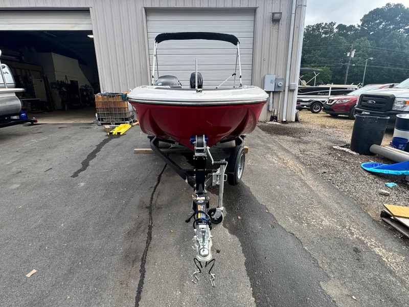 Slide: The Image of 2024 Bayliner Element M15 boat on trailer, parked outside a garage. - 3