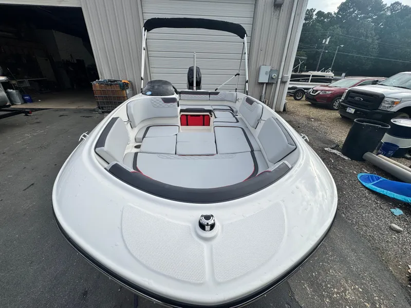 Slide: The Image of 2024 Bayliner Element M15 boat with spacious seating, parked outdoors near a garage. - 7