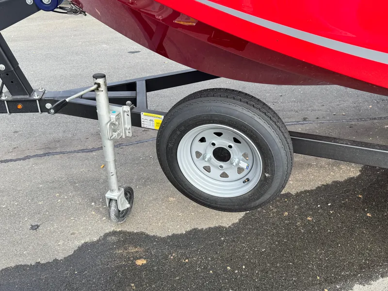 Slide: The Image of 2024 Bayliner Element M15 trailer wheel and support jack on pavement. - 8