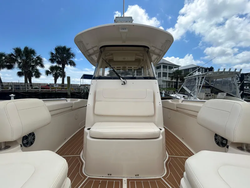 Slide: The Image of 2019 Grady-White Canyon 306 boat interior with seating, docked under a blue sky. - 19
