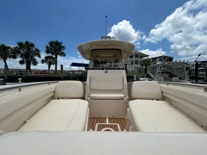 Slide: The Image of 2019 Grady-White Canyon 306 boat interior with seating, docked under a blue sky. - 21