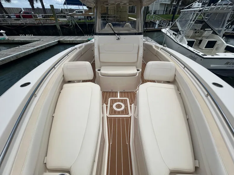 Slide: The Image of 2019 Grady-White Canyon 306 boat interior with white seating and wooden deck. - 22