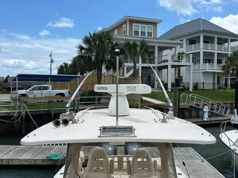 Slide: The Image of 2019 Grady-White Canyon 306 boat docked near waterfront homes, featuring Garmin equipment. - 24