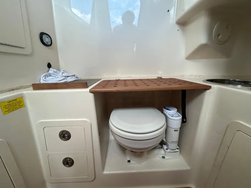 Slide: The Image of 2019 Grady-White Canyon 306 boat interior with compact marine toilet setup. - 32